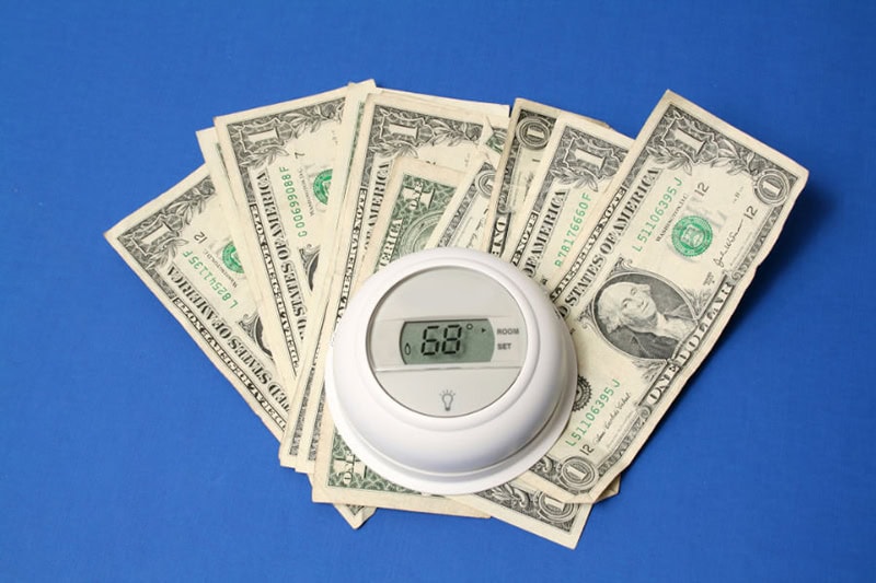 Summer Savings Tips for AC. Money under thermostat.