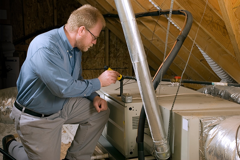 7 Furnace Maintenance Tips - Man Inspecting Furnace.