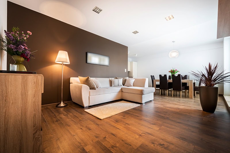 open concept living room with a white couch and dark wood floors.