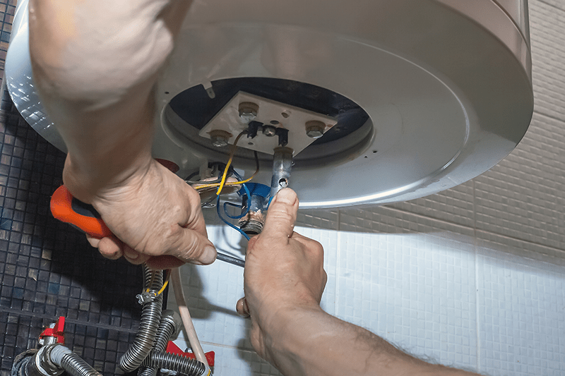 Image of person working on a furnace. What Are Signs I Need a New Furnace?