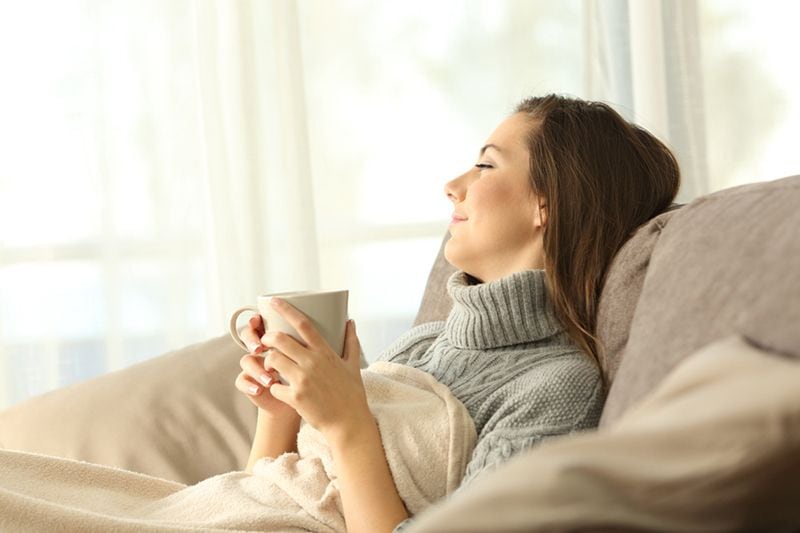 Image of a person sitting on the couch with a cup. What Are Zone Control Systems?